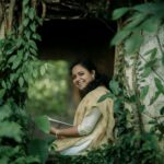 A woman sitting in a hole in the woods